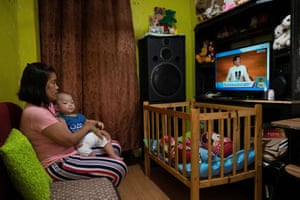 A woman and her son watch Ferdinand Marcos Jr’s first state of the nation address as president on television in Quezon City, the Philippines