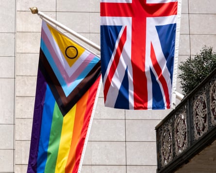 Multicoloured Progress Pride flag hangs alongside a red, white and blue Union Jack