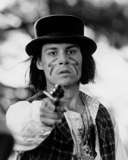 Wearing a top hat and muddied clothes, he points a gun at the camera