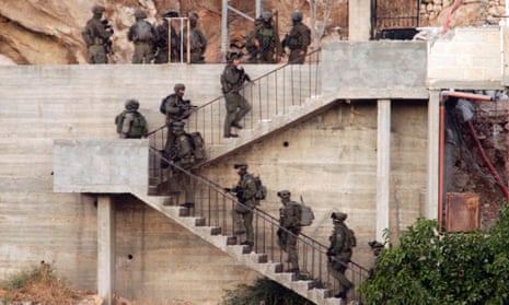 Israeli soldiers raid a house in search of a member of Hamas