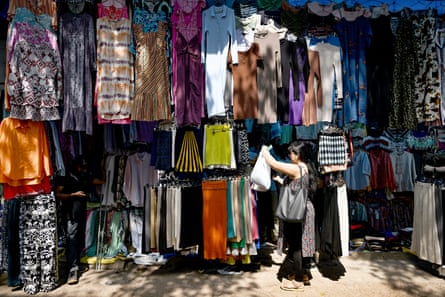 An outdoor stall densely hung with clothing.