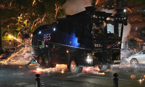 Fireworks explode near a police vehicle in Berlin as demonstrators rally to show support for the Palestinian people following the Gaza City hospital blast