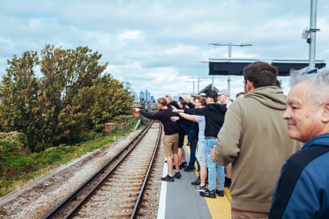 West Ham supporters argue across the rail tracks with Millwall supporters on the road below.