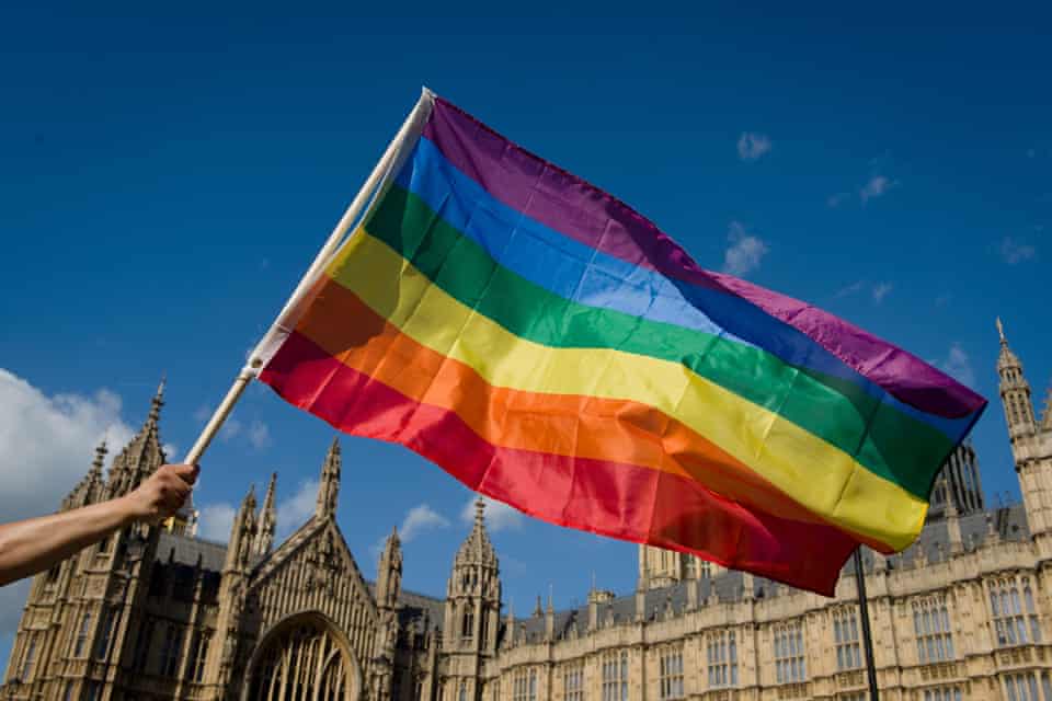 A protester holds a rainbow flag outside the Houses of Parliament in central London in 2013 as people gather in support of same-sex marriage.