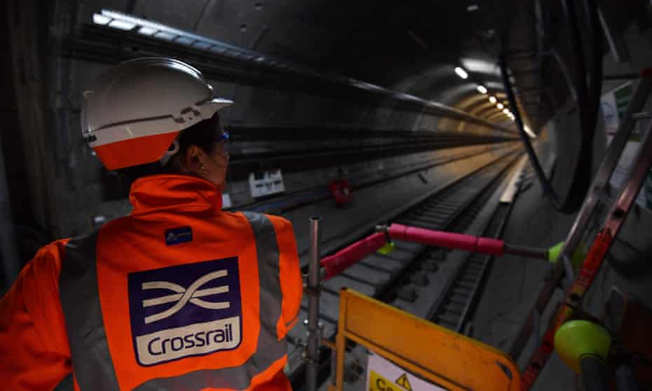 A worker looks along a train tunnel at the Canary Wharf Crossrail station in London
