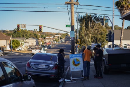 Young men stand and talk on the sidewalk of a suburban street