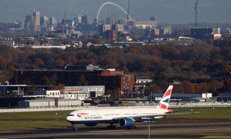 A British Airways Boeing 777 takes off from Heathrow Airport, with the arch of Wembley Stadium in the background, in London.