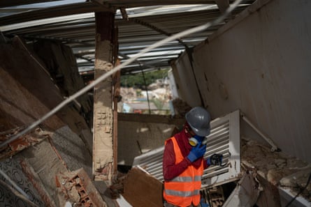 Darwin Rodríguez wearing a hard hat and respirator inside a collapsed building