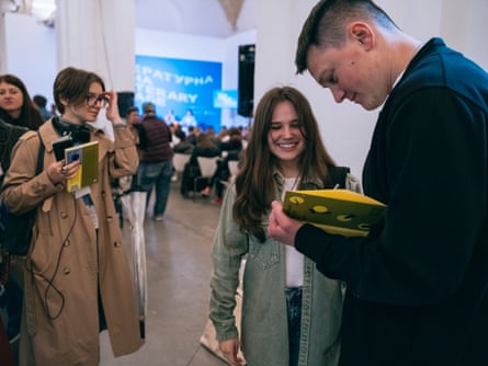 Writer Artur Dron’ signs a book.