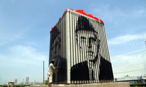 A man cleans a picture of Muhammad Ali Jinnah, the founder of Pakistan, in Karachi.