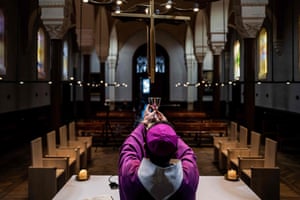 The auxiliary bishop of Lyon, Emmanuel Gobilliard, rehearses before holding a streamed live mass in the empty Saint-Irenee church on Tuesday