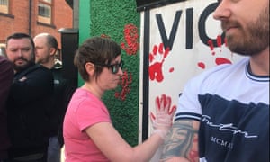 Friends of murdered journalist Lyra McKee painting handprints on the mural outside the headquarters of dissident republican group Saoradh.