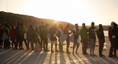 People wait to board a ship that will transfer them on the mainland