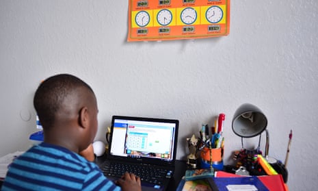 A nine-year-old student Jordan takes part in distance virtual school learning from his bedroom in Broward county, Florida.