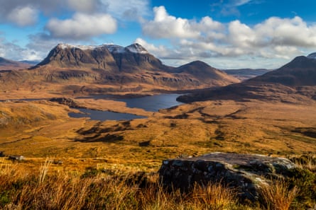 View of peak and lochs set against blue skies