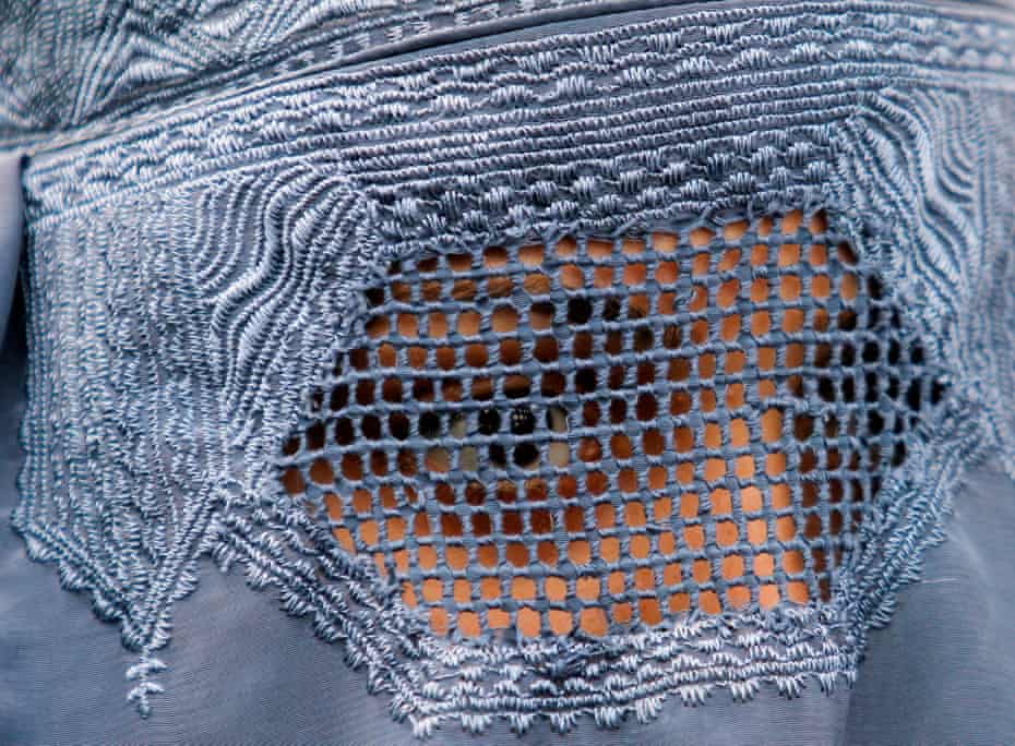 A close up shot of a woman in a burqa with mesh covering her eyes