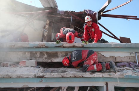 Emergency personnel search for survivors at the site of a collapsed building following a major earthquake in Hatay, Turkey, 9 February.