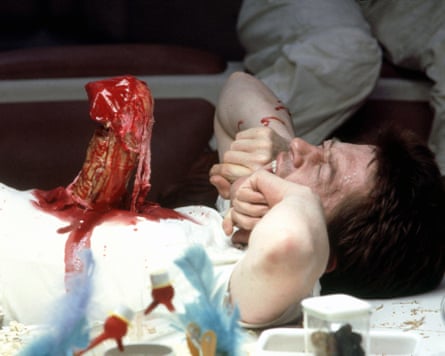 man with bloodied alien-looking creature coming out of his chest