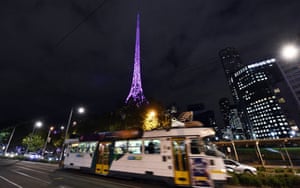 The Melbourne Arts Centre spire is lit in purple