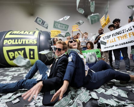 People sit on the floor protesting surrounded by money
