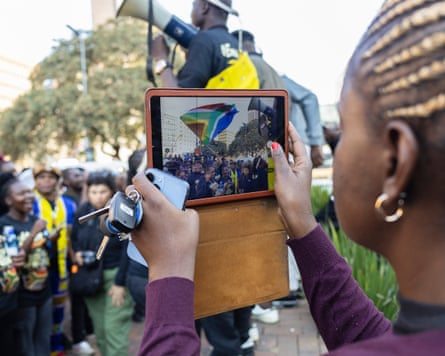 Woman takes a picture at an anti-xenophobia march organised in response to the killing of Nhlamulo Sambo.