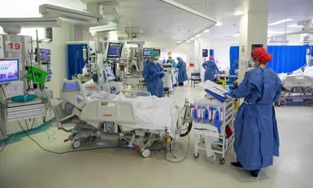 An NHS Covid-19 ward in April, with staff in full PPE around a bed