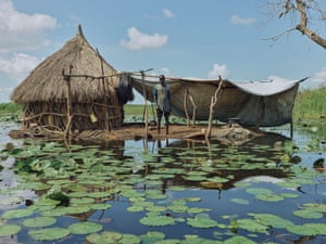 Biel Koryom em sua cabana empoleirada em uma pequena ilha gramada feita pelo homem.