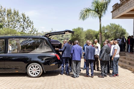 Friends and relatives pull a coffin out of a hearse, Nairobi, Kenya.