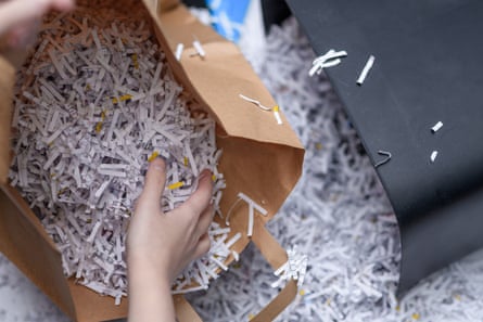 A person holding a bag filled with shredded paper