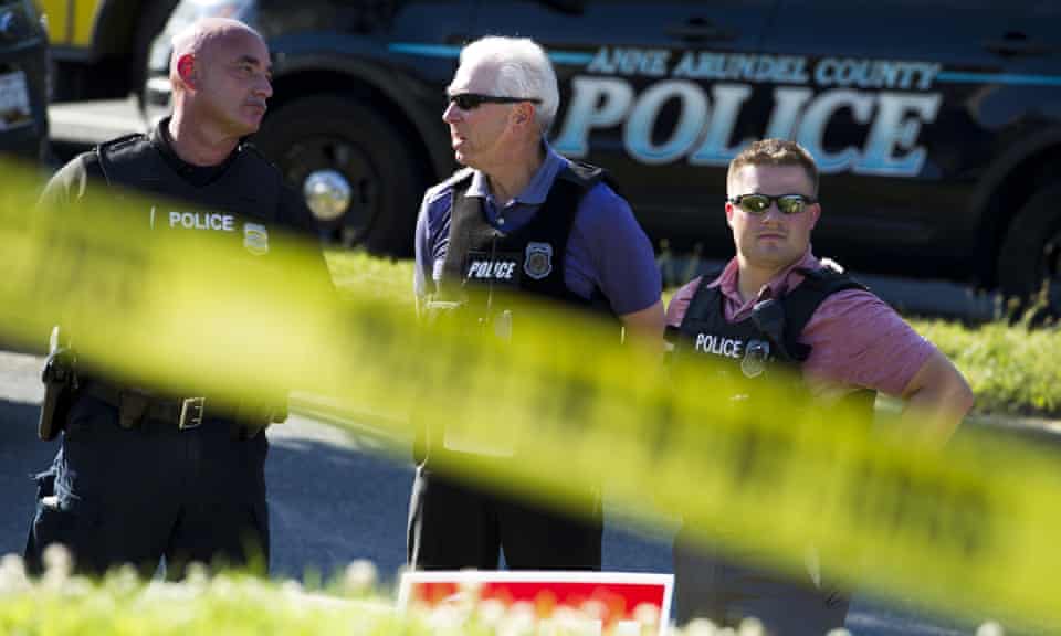 Police officers secure the area around the Capital Gazette newspaper offices – scene of a mass shooting in Annapolis, Maryland.