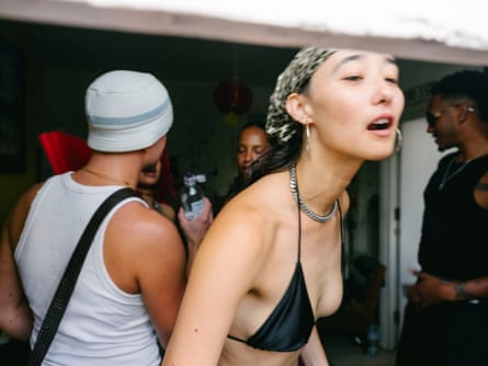 A woman in a bikini top speaks to someone off-camera
