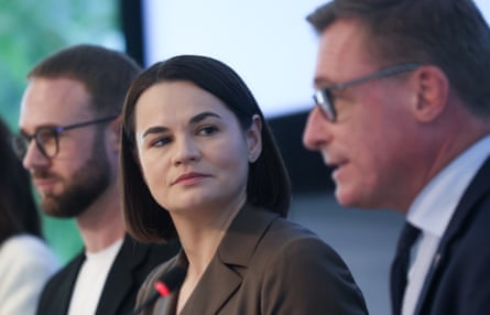 a woman in a brown suit looks to the side