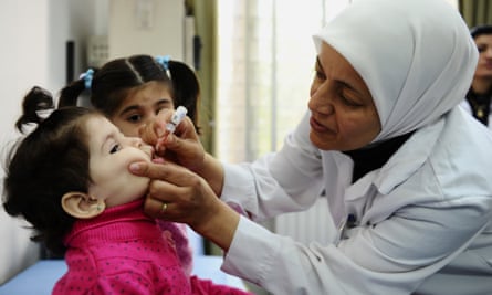 A health worker administers polio vaccine
