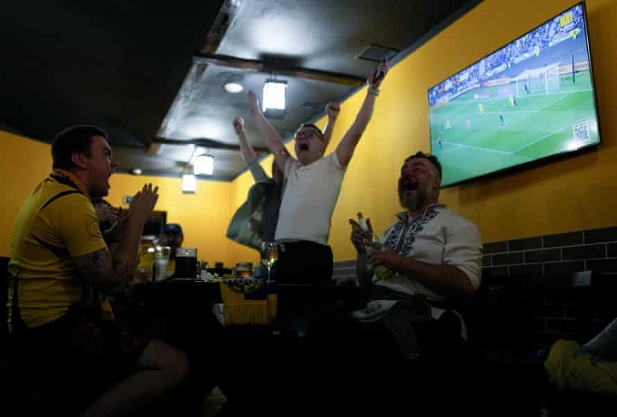 Spectators at a bar in Kyiv, Ukraine, celebrate after Ukraine's Andriy Yarmolenko scored his first goal in a 2022 FIFA World Cup match against Scotland.