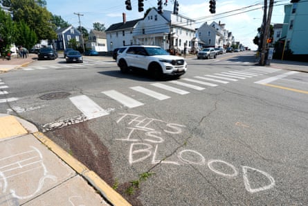 Cars drive by âÂÂthis is bloodâ written in chalk on street next to faint red stains