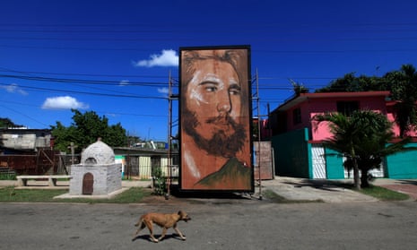 A dog walks past a painting depicting Fidel Castro by Cuban artist Kcho in Havana, Cuba, in August 2016.