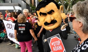 A protestor wearing a mask depicting Adani Group chairman Gautam Adani is seen during a protest against the Carmichael coal mine in Brisbane. 
