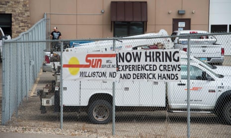 A 'now hiring' banner decked to a car park fence