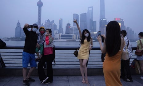 Residents pose for photos along the Bund in Shanghai. 