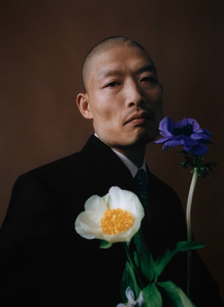 Yousuke Yukimatsu poses behind a bunch of flowers