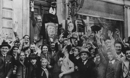 A jubilant crowd bearing images of Churchill and Roosevelt gathers outside the home of a Nazi collaborator in Brussels to celebrate the liberation of Belgium by Allied forces