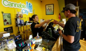 Jessica Mann, left, gives change to a customer at Cannabis City in Seattle.