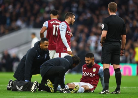 Douglas Luiz receives medical attention after going down with a knee problem.