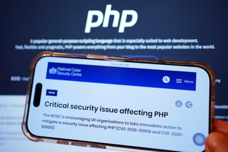 A phone screens shows a notice on the National Cyber Security Centre website warning of a critical security issue affecting PHP.