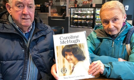 Philomena McHugh, holding a picture of her daughter Caroline with the caption “They never came home”, sits next to her husband Maurice, both wearing jackets