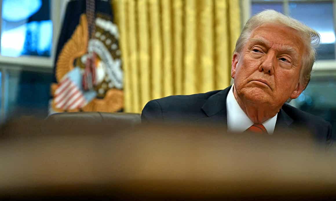 The US president sits in the Oval Office of the White House on 10 February.