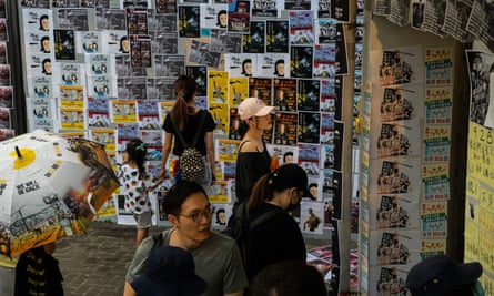People look at posters on the ‘Lennon wall’.