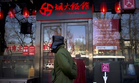 A man walks past a branch of Beijing’s Huda restaurant chain