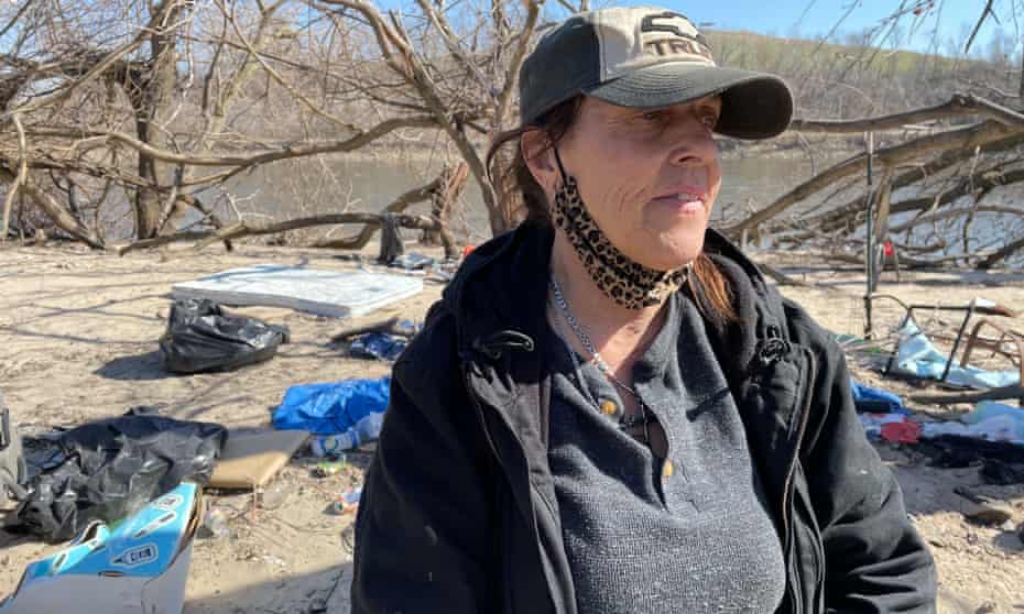 Terri Domer visits the riverside encampment in Cedar Rapids, where she weathered last August's derecho.