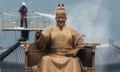 A worker sprays water on to the statue of King Sejong in Seoul, Korea.